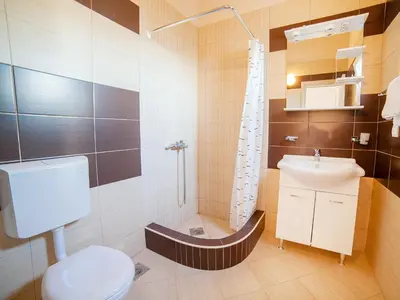 a bathroom with a toilet and a sink and a shower at Pansion Nobel in Petrovac na Moru