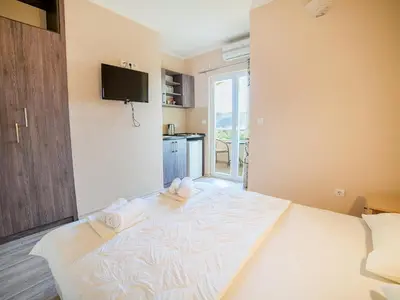 a bedroom with a large bed with towels on it at Pansion Nobel in Petrovac na Moru