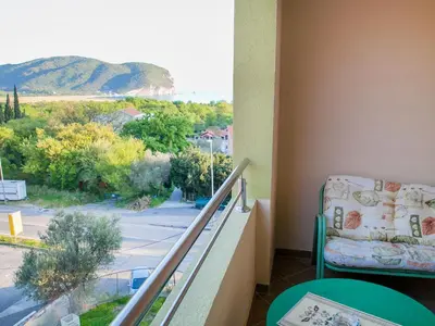 a balcony with a chair and a view of a street at Pansion Nobel in Petrovac na Moru