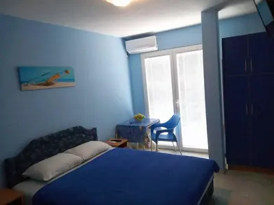 a bedroom with a bed and a table and a chair at Apartmani Lekovic Sutomore in Sutomore