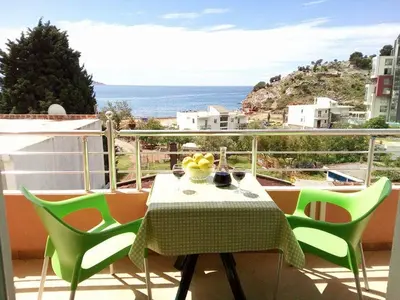 a table and chairs on a balcony with a view of the ocean at Apartmani Lekovic Sutomore in Sutomore