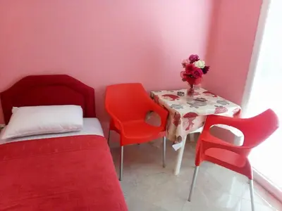 a room with a table and two chairs and a bed at Apartmani Lekovic Sutomore in Sutomore