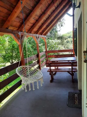 a porch with a swinging chair and a bench at LOVCEN4ME in Cetinje