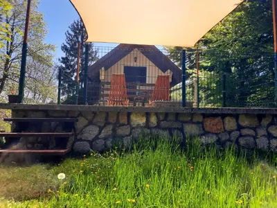 a gazebo with orange chairs on a stone wall at LOVCEN4ME in Cetinje