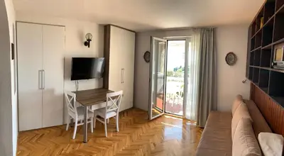 a living room with a table and a television at Reževići Apartments in Petrovac na Moru