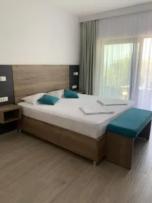 a bedroom with a large bed with blue pillows at Reževići Apartments in Petrovac na Moru