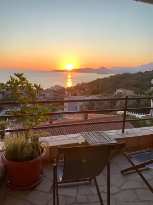 a view of the sunset from the balcony of a house at Reževići Apartments in Petrovac na Moru