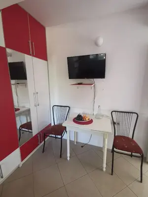 a room with a table and two chairs and a tv at Apartments Coso Zlatne njive bb in Kotor