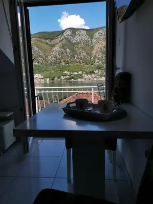 a table in a room with a view of a mountain at Apartments Coso Zlatne njive bb in Kotor