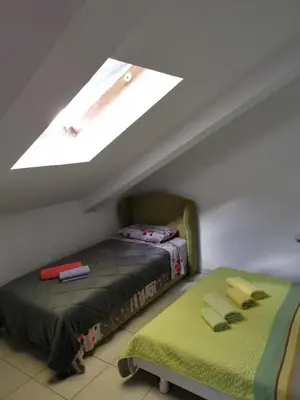 a attic room with a bed and a window at Apartments Coso Zlatne njive bb in Kotor