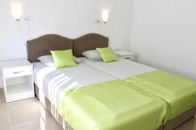 a bedroom with a large bed with green pillows at Apartments Villa Milna 1 in Budva