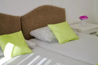 a white couch with green pillows on it at Apartments Villa Milna 1 in Budva