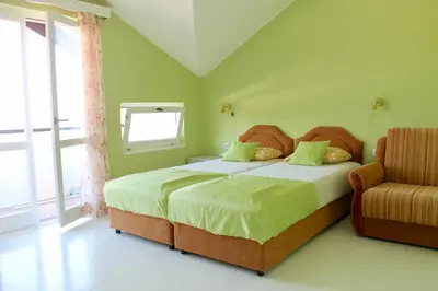 a bedroom with a bed with a chair and a window at Apartments Villa Milna 2 in Budva