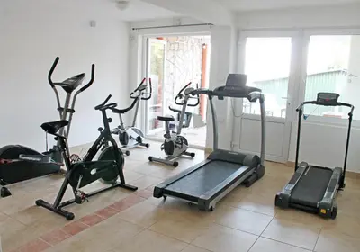 a gym with several exercise bikes in a room at Apartments Villa Milna 2 in Budva
