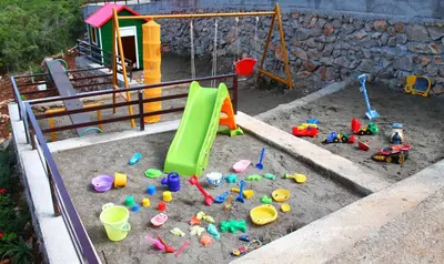 a childs play area with toys in a sandbox at Apartments Villa Milna 2 in Budva
