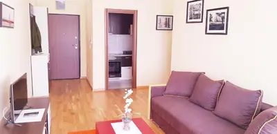 a living room with a purple couch and a table at Olimp Lux in Budva