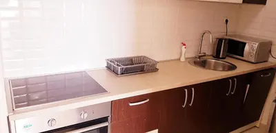 a kitchen counter with a sink and a microwave at Olimp Lux in Budva
