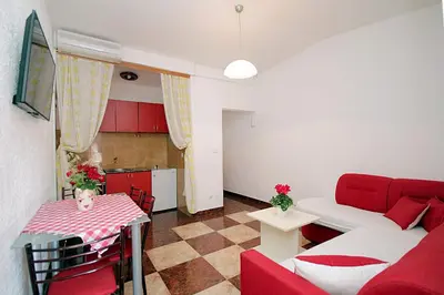 a living room with a red couch and a table at Apartments Kruna Jovanović in Sutomore