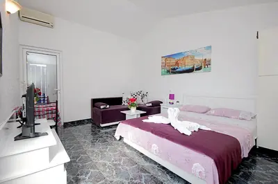 a bedroom with a bed and a tv and a couch at Apartments Kruna Jovanović in Sutomore
