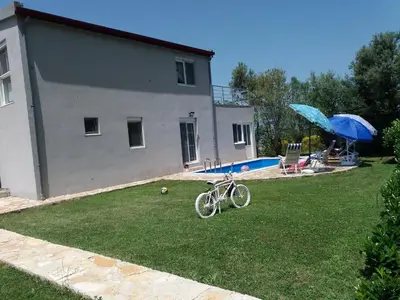 a bike parked in a yard next to a house at Zelena Maslina in Bar