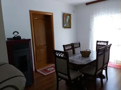 a dining room with a table and chairs and a fireplace at Zelena Maslina in Bar