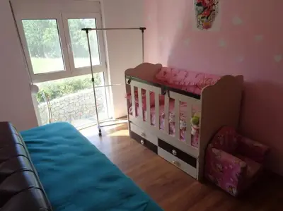 a childs bedroom with a crib and a window at Zelena Maslina in Bar