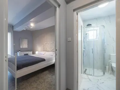 a bedroom with a bed and a glass shower at Apartments Cataleya Przno in Sveti Stefan