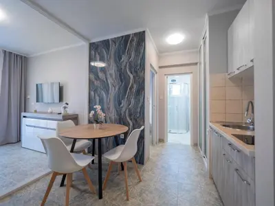 a kitchen with a table and chairs in a room at Apartments Cataleya Przno in Sveti Stefan