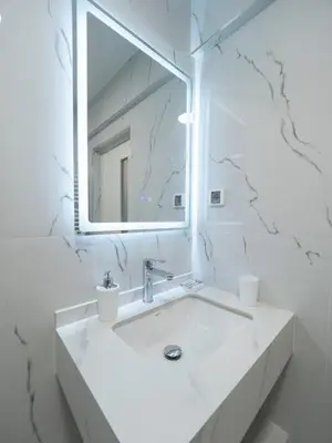 a white bathroom with a sink and a mirror at Apartments Cataleya Przno in Sveti Stefan