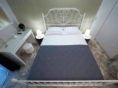 a bedroom with a large bed and two lamps at Apartments Cataleya Przno in Sveti Stefan