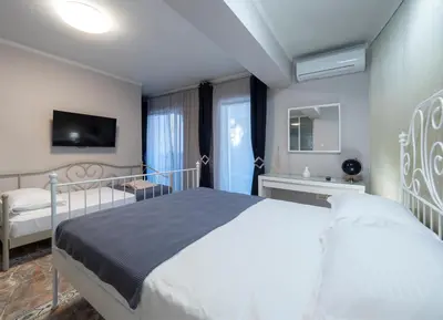 a bedroom with a large bed and a tv at Apartments Cataleya Przno in Sveti Stefan
