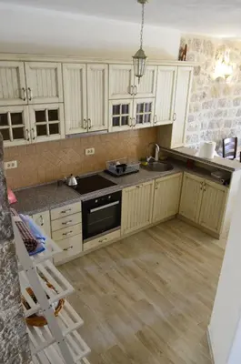 a kitchen with white cabinets and a sink and a stove at Vila Nikola in Bratesici