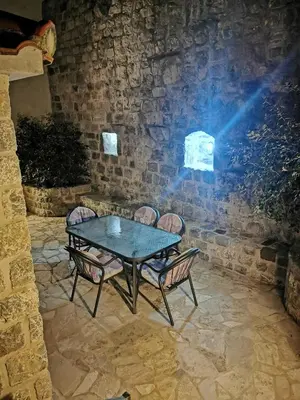 a table and chairs in a stone room with a spotlight at Vila Nikola in Bratesici