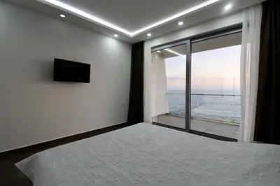 a bedroom with a bed and a window with a view at Apartments Komina in Utjeha