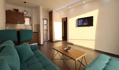 a living room with a blue couch and a table at Apartments Komina in Utjeha