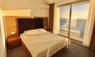 a bedroom with a bed and a large window at Apartments Komina in Utjeha