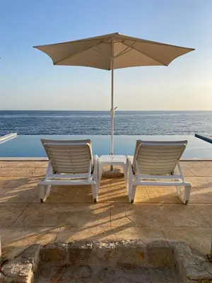two chairs and an umbrella on the beach at Apartments Komina in Utjeha