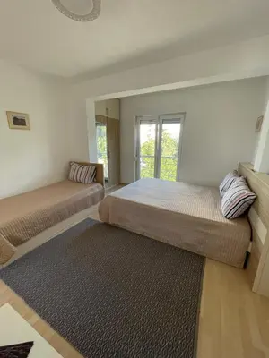 a bedroom with two beds and a rug at Villa Dobre Vode in Dobra Voda
