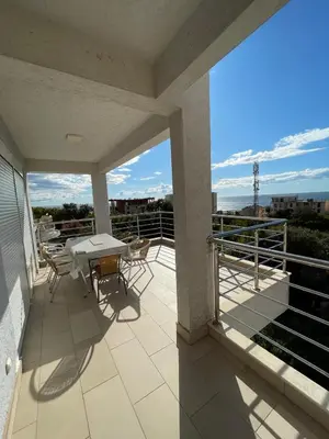 a patio with a table and chairs on a balcony at Villa Dobre Vode in Dobra Voda