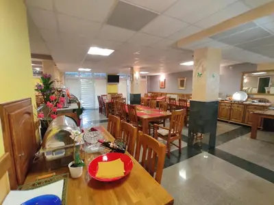 an empty restaurant with wooden tables and chairs at Villa Aleksandra - T in Rafailovici