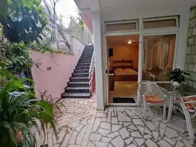 a patio with stairs and a table and chairs at Villa Aleksandra - T in Rafailovici