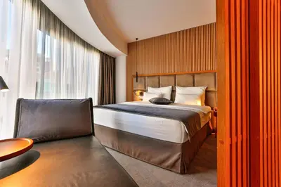 a hotel room with a bed and a chair at Hotel Fagus by Aycon in Budva