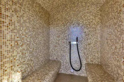 a shower in a tiled bathroom with two benches at Hotel Fagus by Aycon in Budva