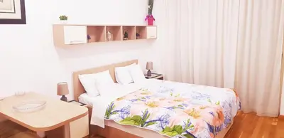 a bedroom with a bed and a table in it at Olimp Lux II in Budva