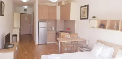 a small kitchen with a table and a white refrigerator at Olimp Lux II in Budva