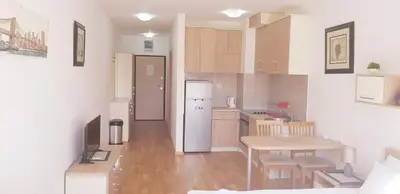 a small kitchen with a table and a refrigerator at Olimp Lux II in Budva