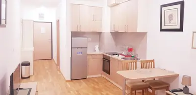 a small kitchen with a table and a refrigerator at Olimp Lux II in Budva