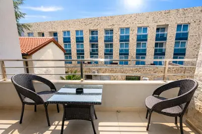 a balcony with a table and chairs and a building at Hotel Butua Residence in Budva