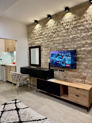 a living room with a tv on a stone wall at Hotel RESIDENCE in Ulcinj