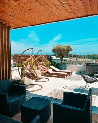 a patio with chairs and a swing on a roof at Hotel RESIDENCE in Ulcinj